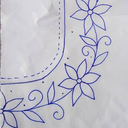 a piece of white paper with blue stitching on it and a flower design in the center