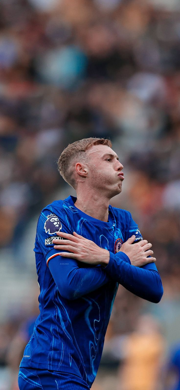 a soccer player with his arms crossed looking up