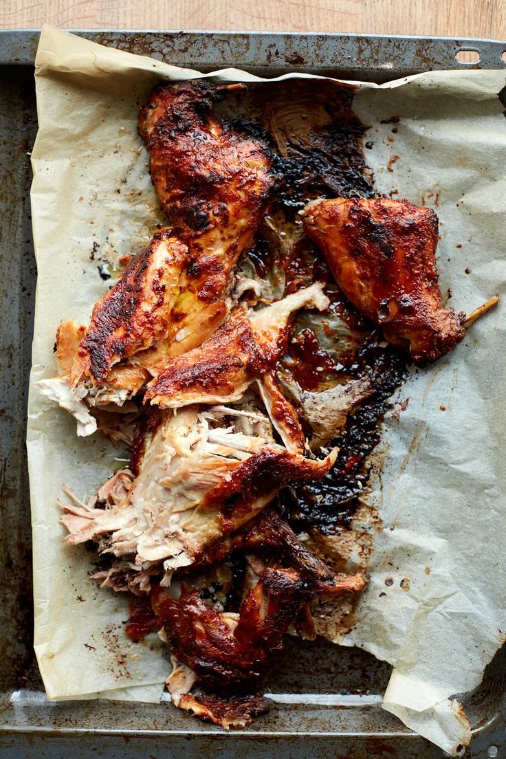 some meat is laying on top of a piece of paper in a baking pan, ready to be cooked