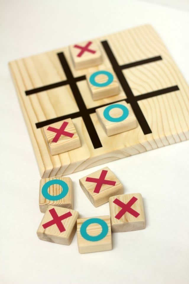 wooden tic - tac - toe game with pieces cut out to look like x and o