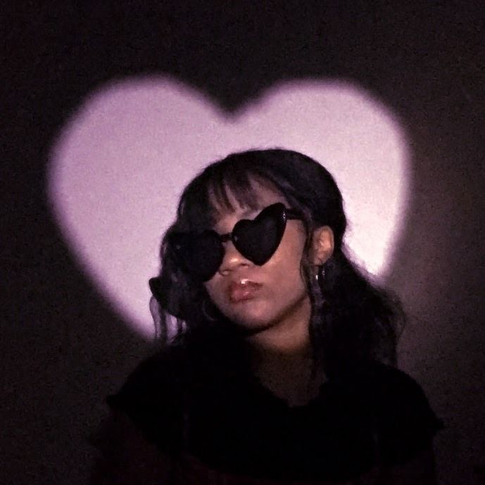 a woman wearing heart shaped sunglasses in the dark