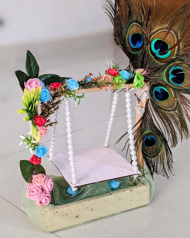 a peacock feather decoration with beads and flowers