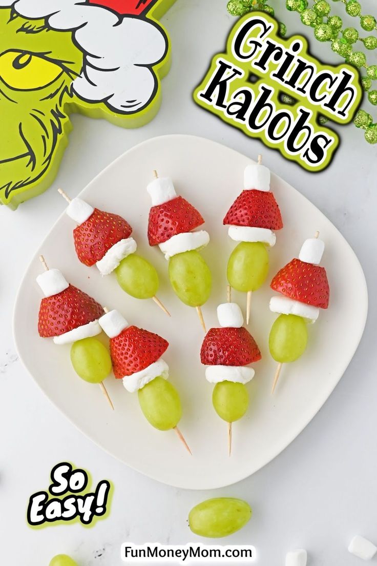 a plate with strawberries and grapes on skewers for grin - face kabobs