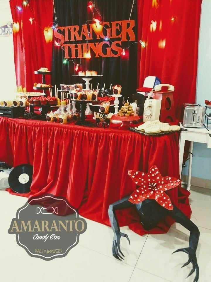 there is a table that has many things on it and red drapes over it