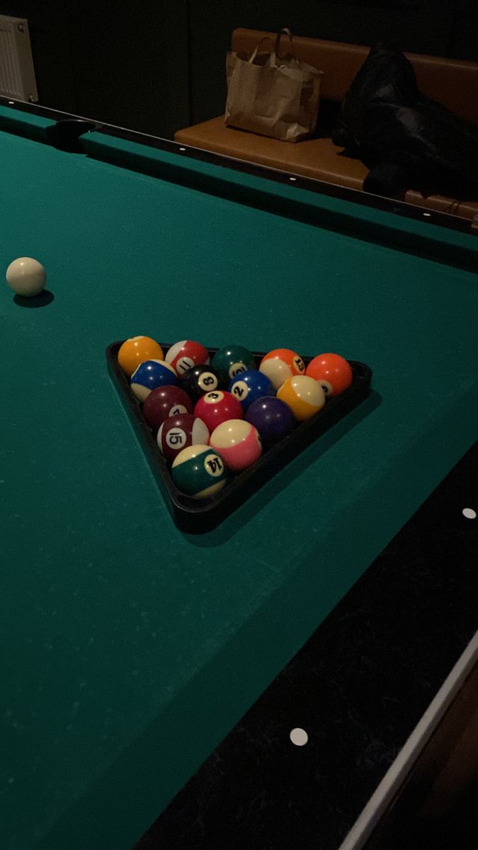 a pool table with several billiards and balls on it in a dark room