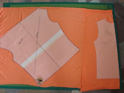 an orange piece of paper with white lines on it and another piece of fabric next to it