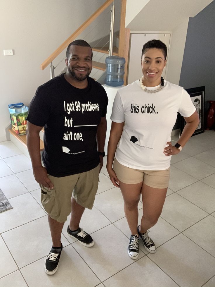 two people standing next to each other in front of a kitchen counter and tiled floor