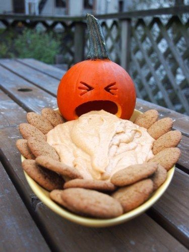 a pumpkin sitting on top of a plate filled with cookies