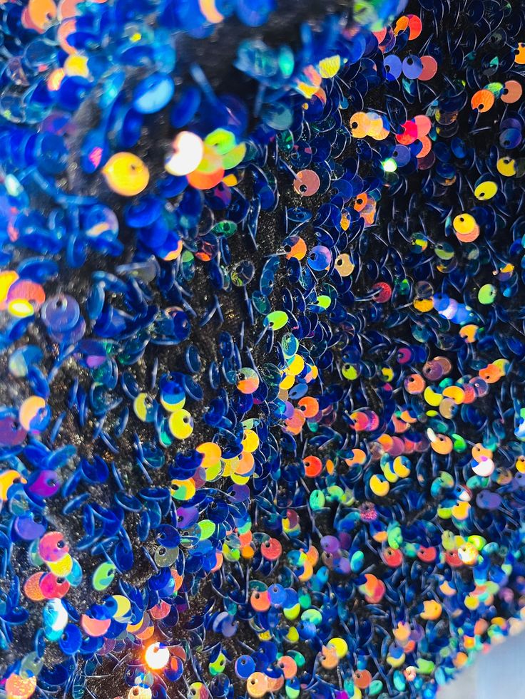 a close up view of colorful beads on a table top with lights in the background