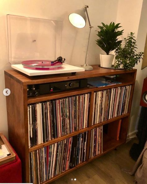 a record player sitting on top of a wooden shelf