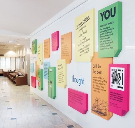 colorful sticky notes are on the wall in an office lobby with white tile flooring