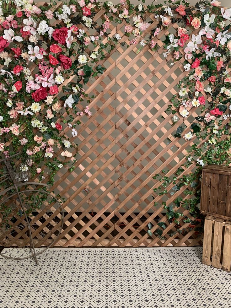 a wooden fence with pink and white flowers growing on it, next to a planter