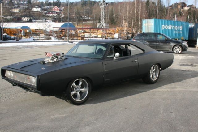 a black muscle car parked in a parking lot