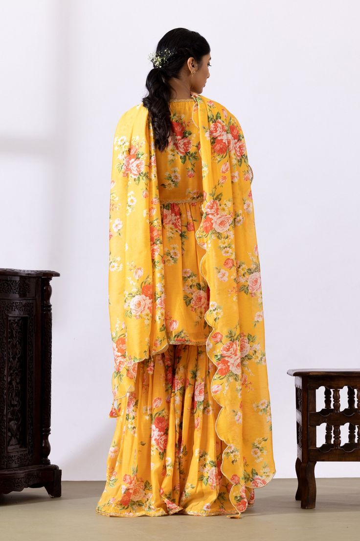 Mustard yellow gathered kurta with floral digital prints and lace detailing. Paired with printed gharara and dupatta.
Components: 3
Pattern: Printed
Type Of Work: Floral
Neckline: V neck
Sleeve Type: Three quarter
Fabric: Chanderi
Color: Yellow
Other Details: 
Lace detailing
Tassel tie-up
Tassel detailing on edge of dupatta
Scallop border
Occasion: Puja - Aza Fashions Scallop Border, Types Of Work, Set For Women, Yellow Floral, Anarkali, Aza Fashion, Mustard Yellow, Sleeve Type, Three Quarter