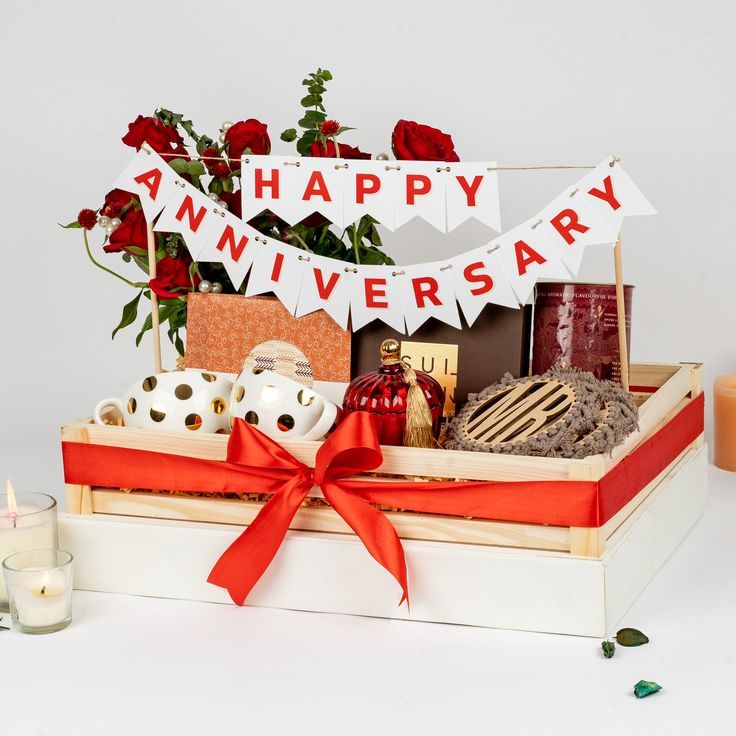 a gift box with flowers, candles and other items for a anniversary party or special occasion