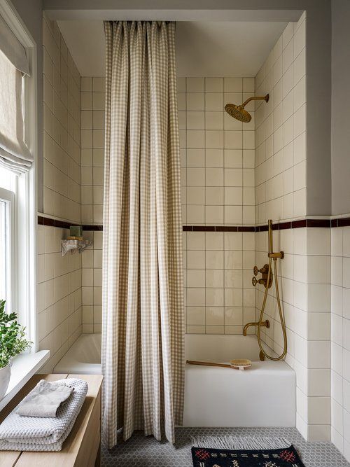 a bathroom with a bathtub, shower curtain and rug in front of the window