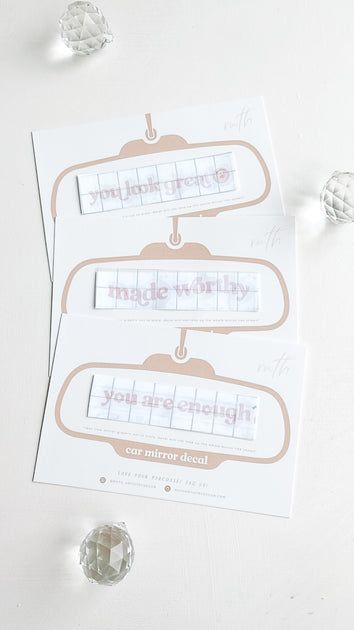 two pieces of paper sitting next to each other on top of a white table with crystal beads