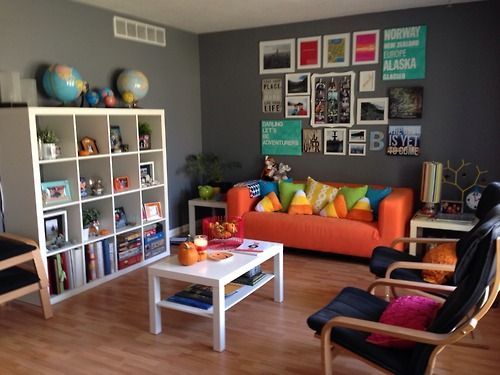 a living room filled with lots of furniture and pictures on the wall above it's bookshelves