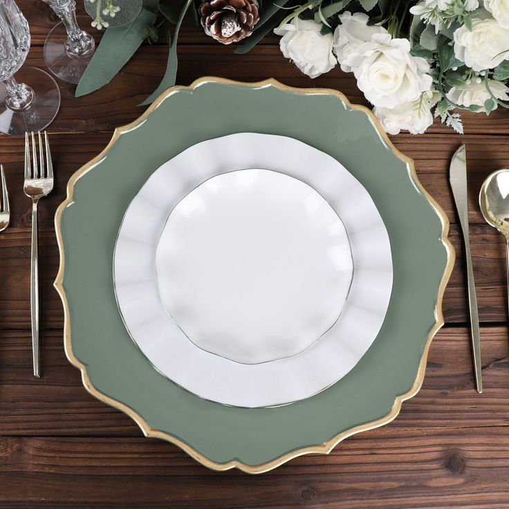 a table setting with white flowers and silverware