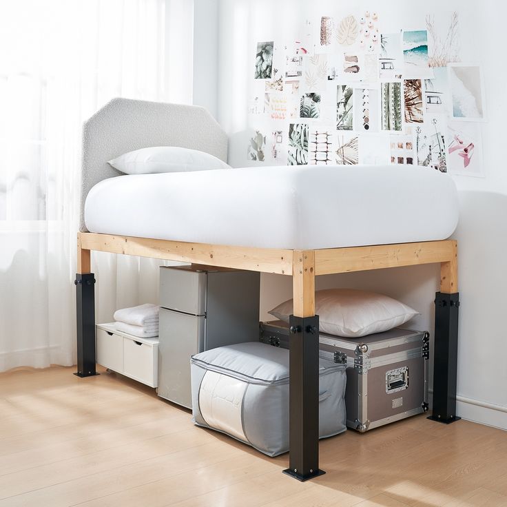 a white bed sitting on top of a wooden floor next to a window with curtains