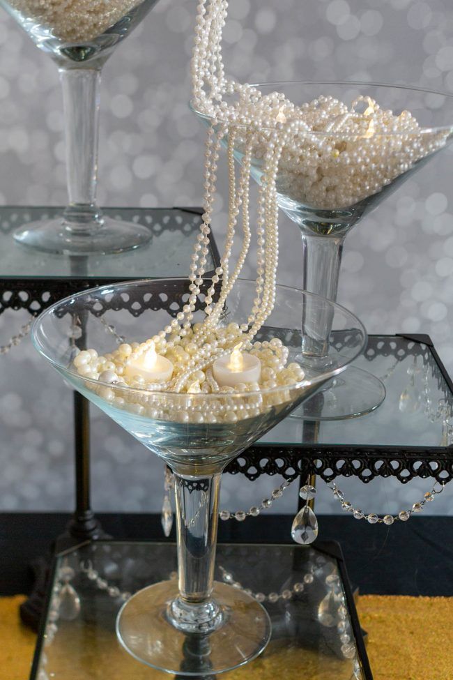 two martini glasses filled with pearls on top of a table