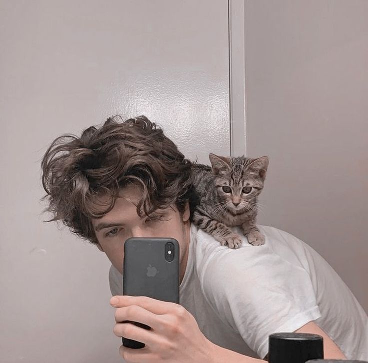 a young man taking a selfie with his cat