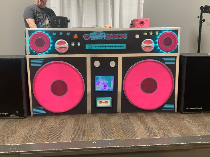 a man standing next to a boombox with speakers on it