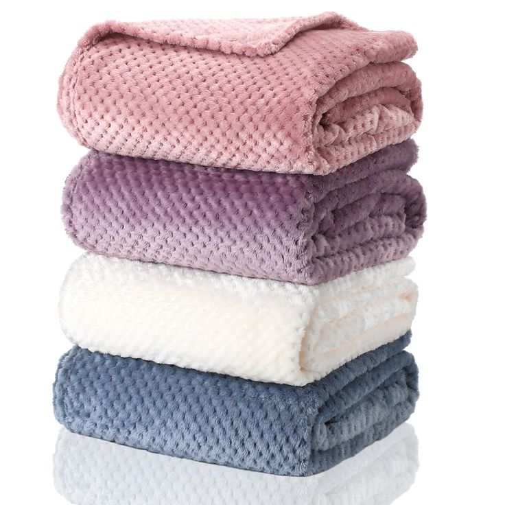 towels stacked on top of each other in different colors and patterns, all folded up