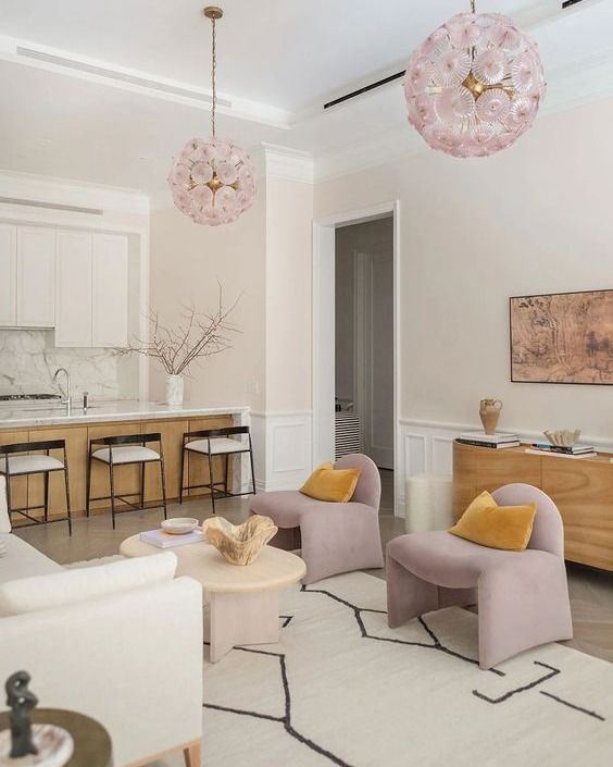 a living room filled with furniture and a chandelier hanging over the top of it