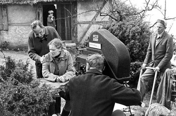 black and white photograph of people sitting in front of a camera set up for filming