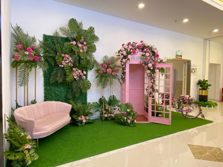 a room with pink furniture and flowers on the walls