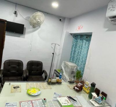 an office with chairs and desks in the corner, including a fan hanging from the ceiling