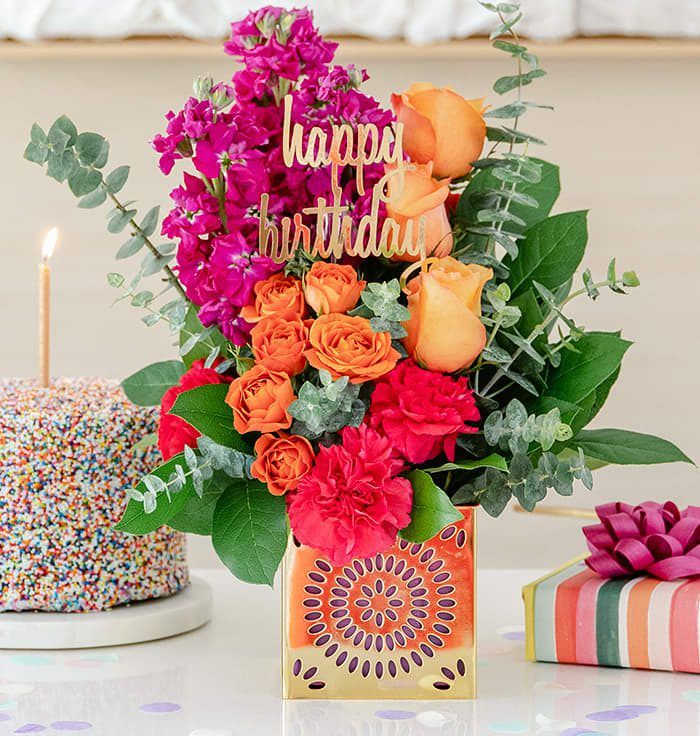 a birthday cake and flowers on a table