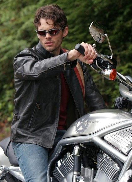 a man riding on the back of a silver motorcycle