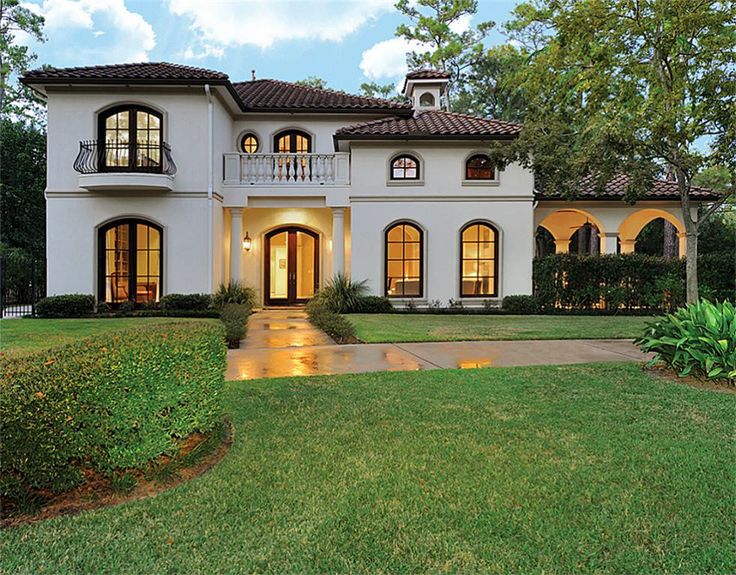 a large white house with lots of windows on it's front porch and landscaping