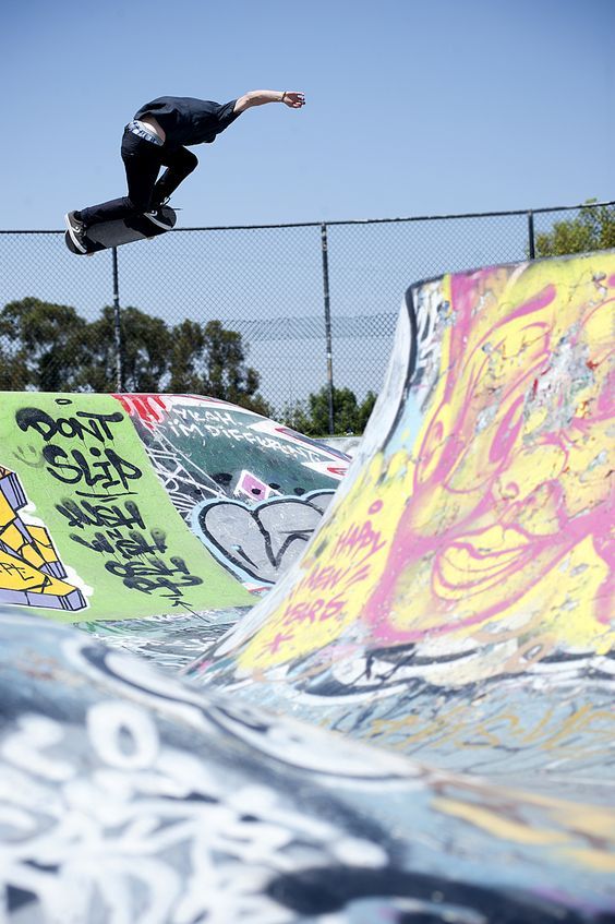 a man riding a skateboard up the side of a ramp at a skate park