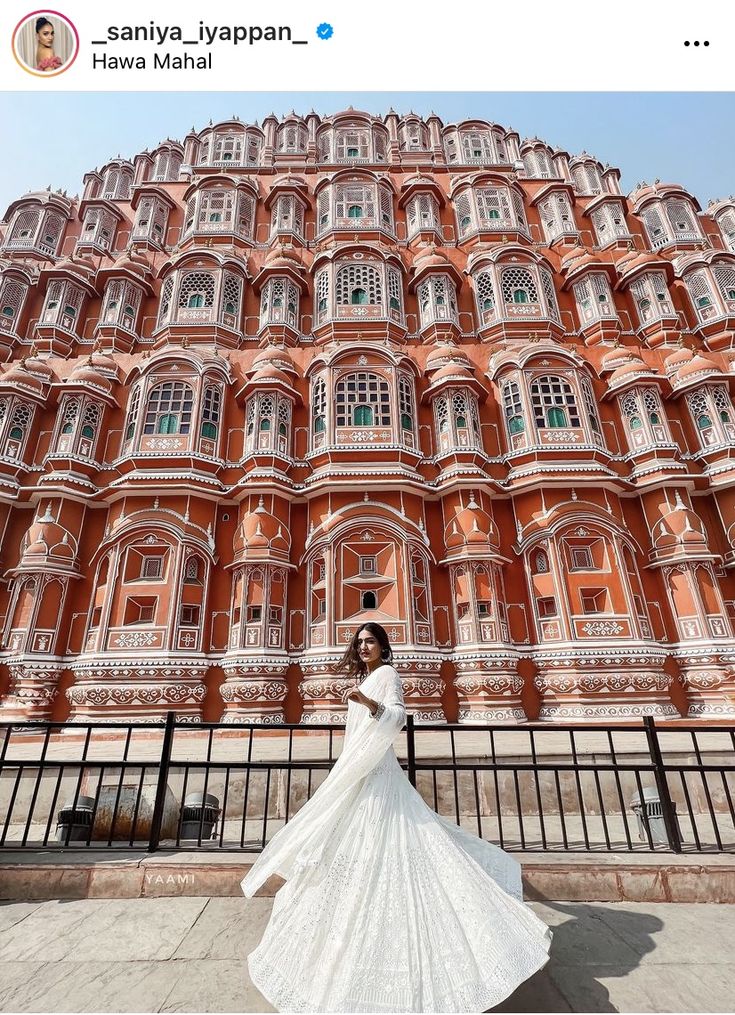 a woman standing in front of a tall building