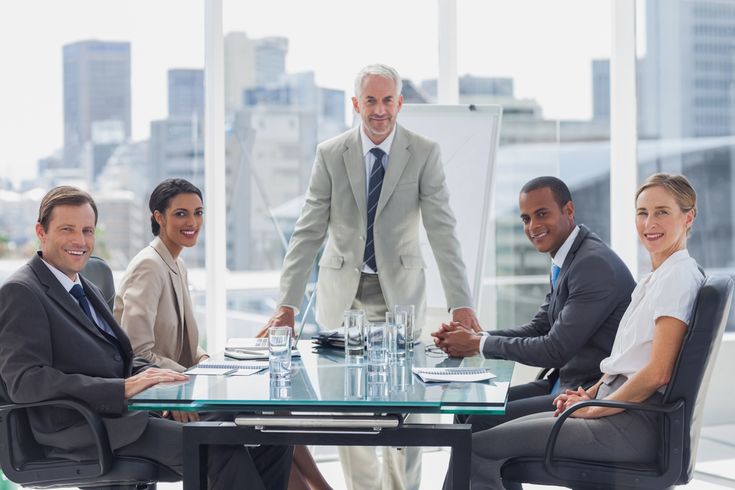 a group of business people sitting around a conference table