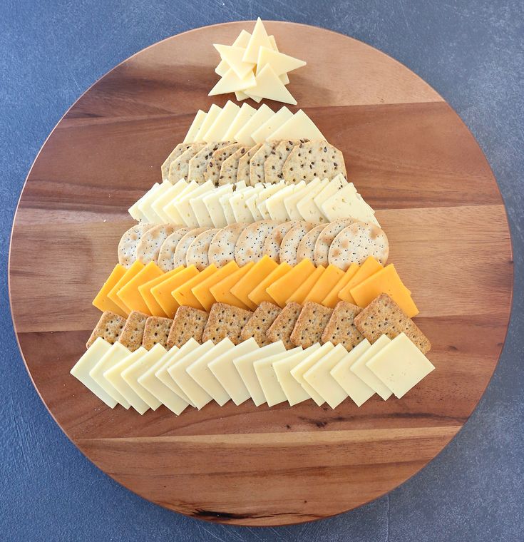 a wooden plate topped with cheese and crackers