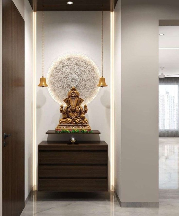 a golden buddha statue sitting on top of a wooden table in front of a doorway