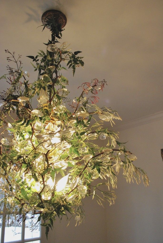 a chandelier hanging from the ceiling in a room with white walls and windows