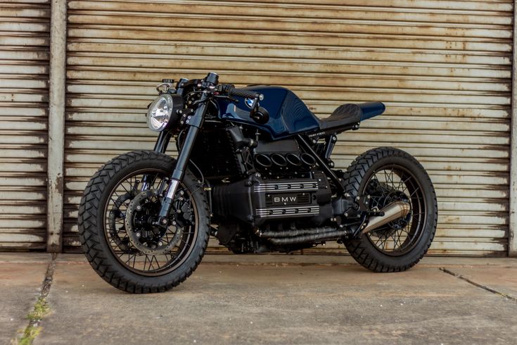 a black motorcycle parked in front of a garage door