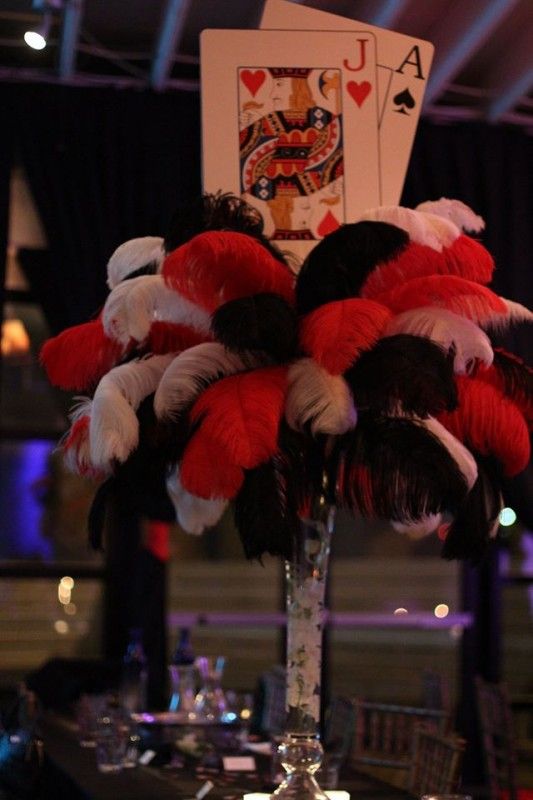 a tall vase filled with lots of red and white feathers