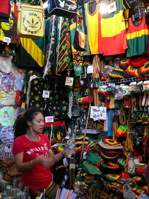 a woman standing in front of a store filled with colorful items