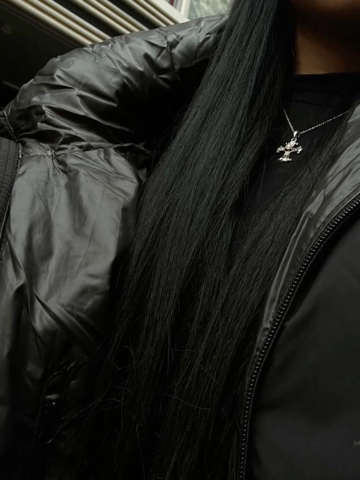 a woman with long black hair wearing a jacket