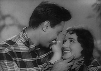 a man and woman laugh together in an old black - and - white photo from the 1950's