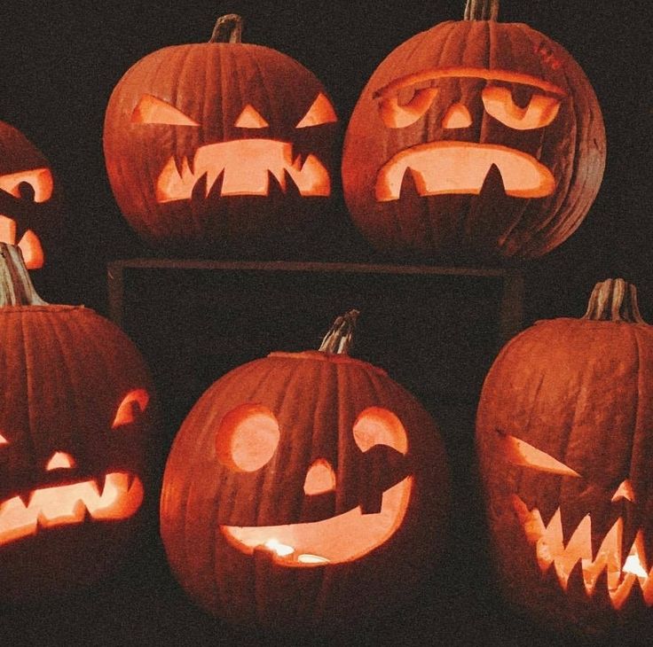 several carved pumpkins with faces on them