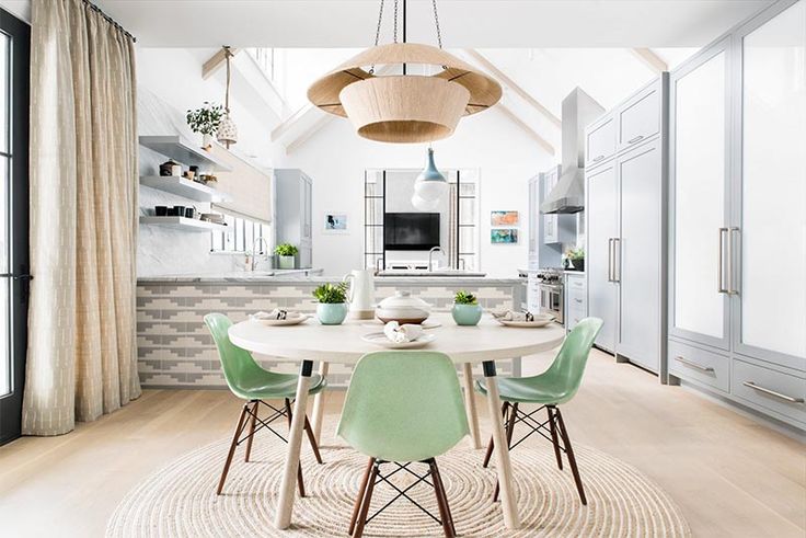 a dining room table with green chairs around it and an area rug on the floor