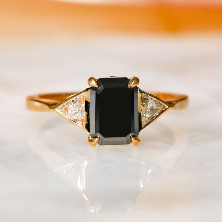 a black and white diamond ring sitting on top of a table