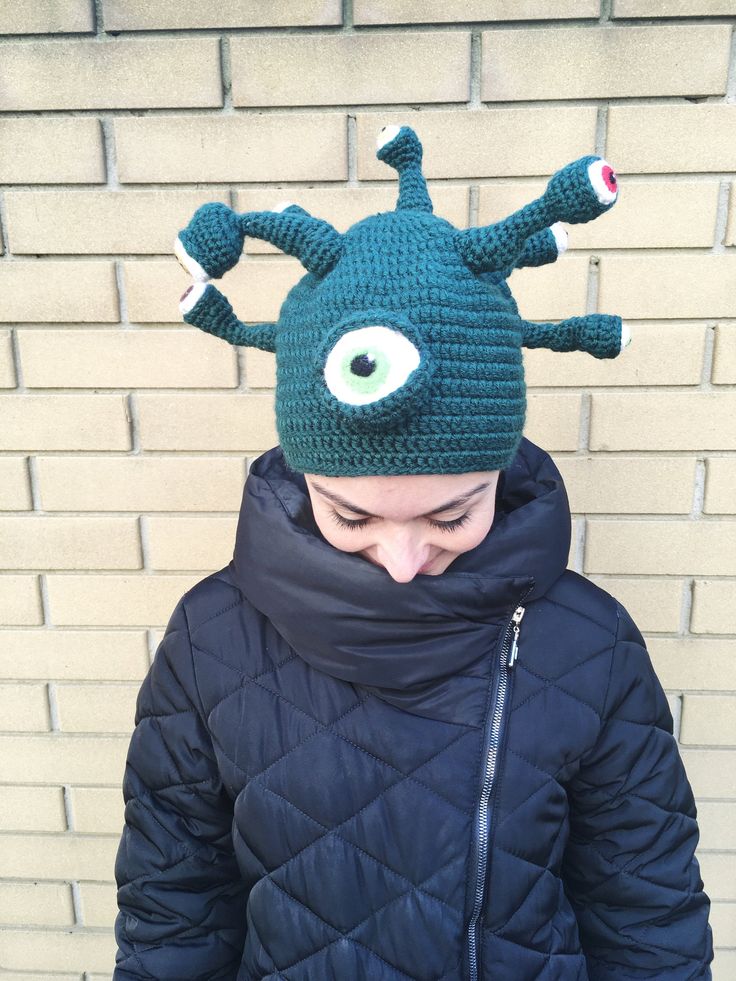 a person wearing a knitted hat with an eyeball on it